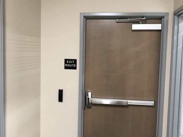 Office corridor door with an exit device, a door closer and a card reader