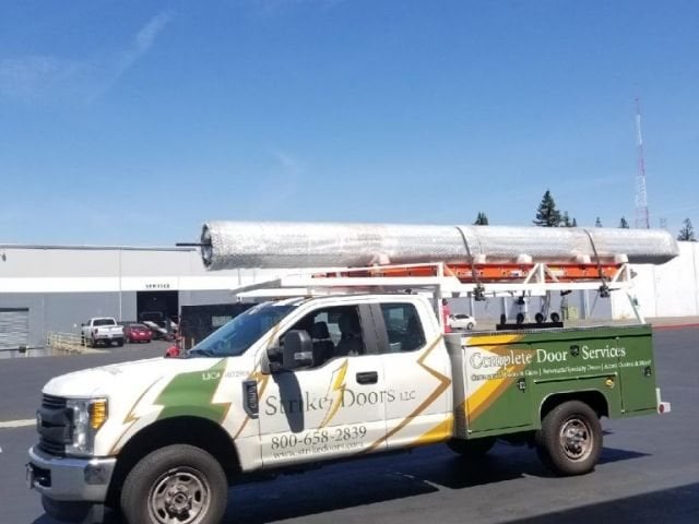 Strike Doors service truck with a wrapped load on its rack